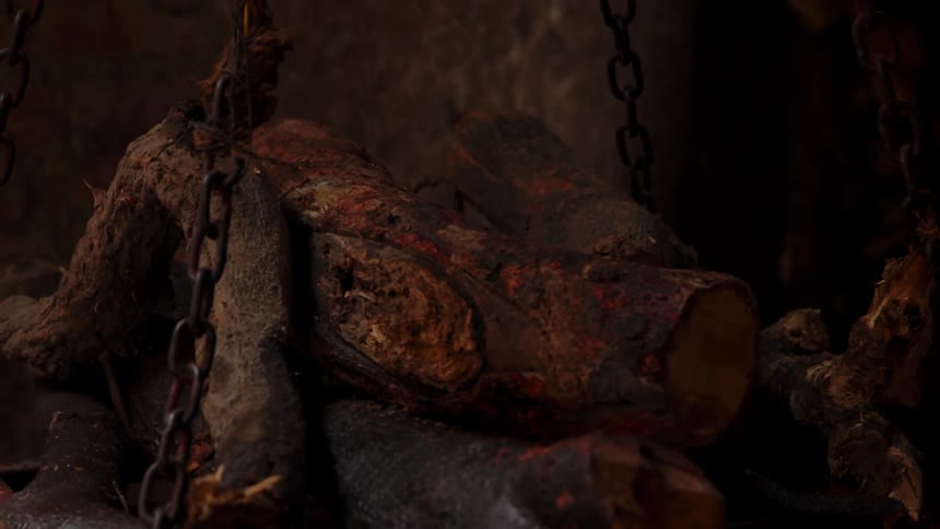 A chain swings burnt wood