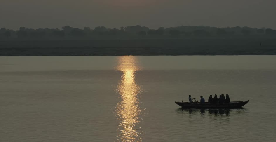 Boat being rowed in the water under the moonlight