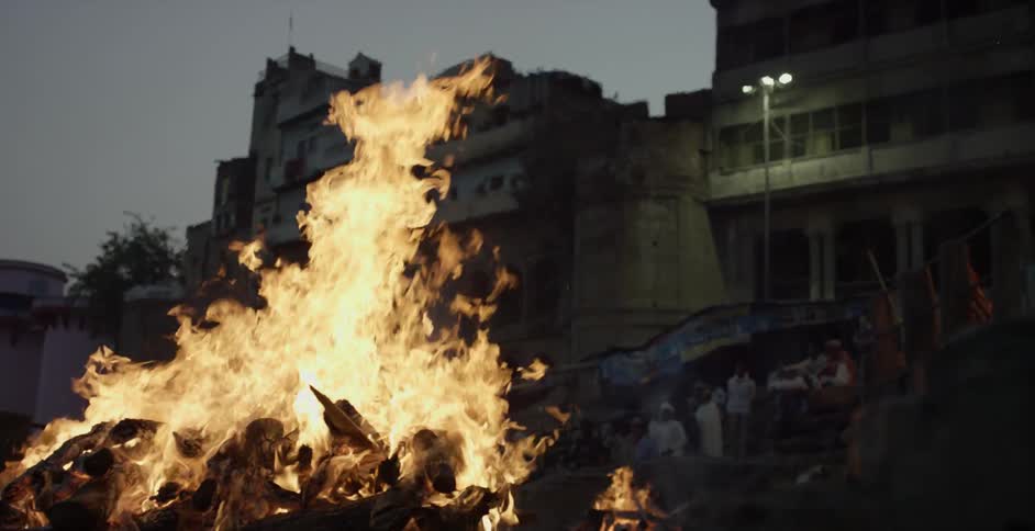 A large fire is burning outside some buildings