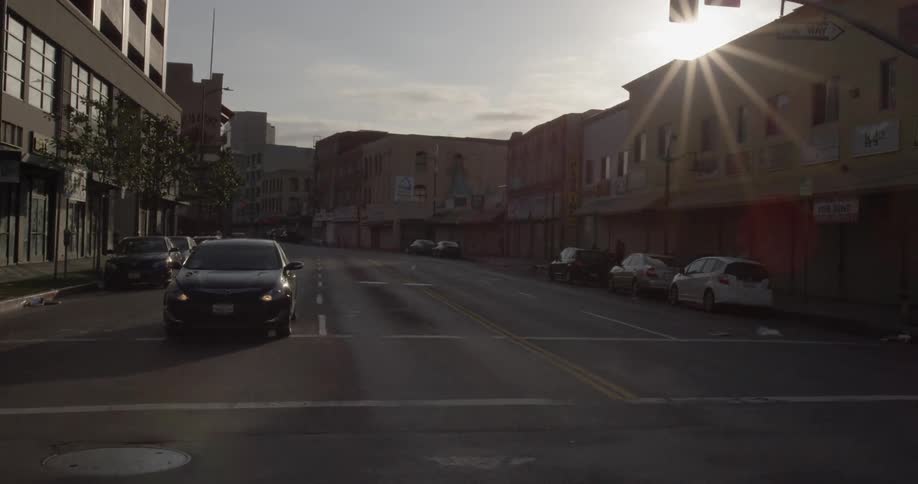 Vehicles sit parked on the side of city streets