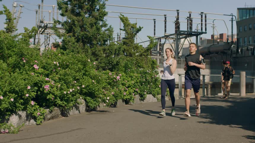 People jog near flower bushes