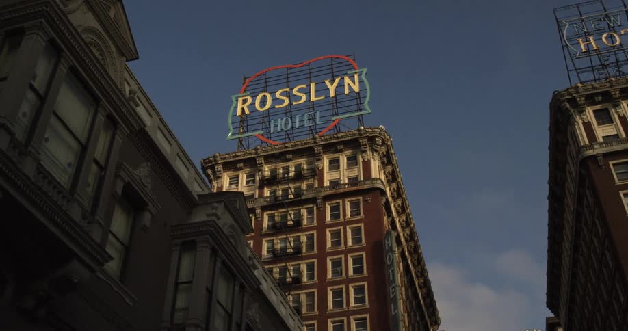Two tall buildings have hotel signs at the top