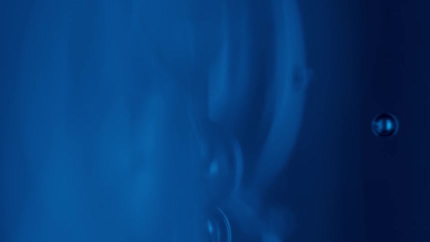Blue bubbles move around in a dark area