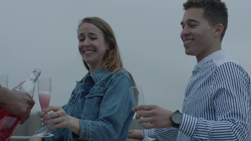A group of people are standing around about to drink some sparkling wine