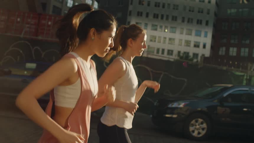 Two women jog in the street