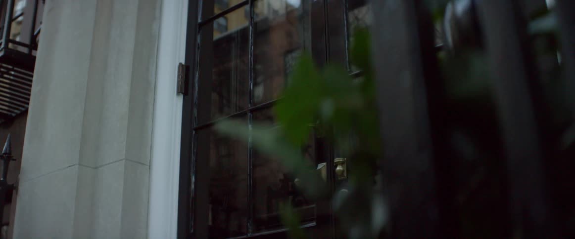 Glass doors reflect city buildings