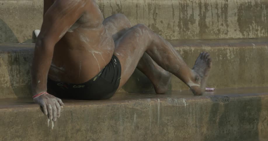 A dusty man rubs his feet on a step