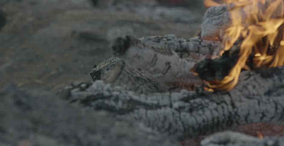 A person walks near a fire