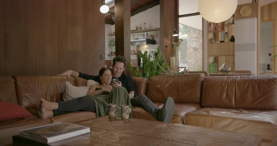 A man and woman cuddle on a couch together