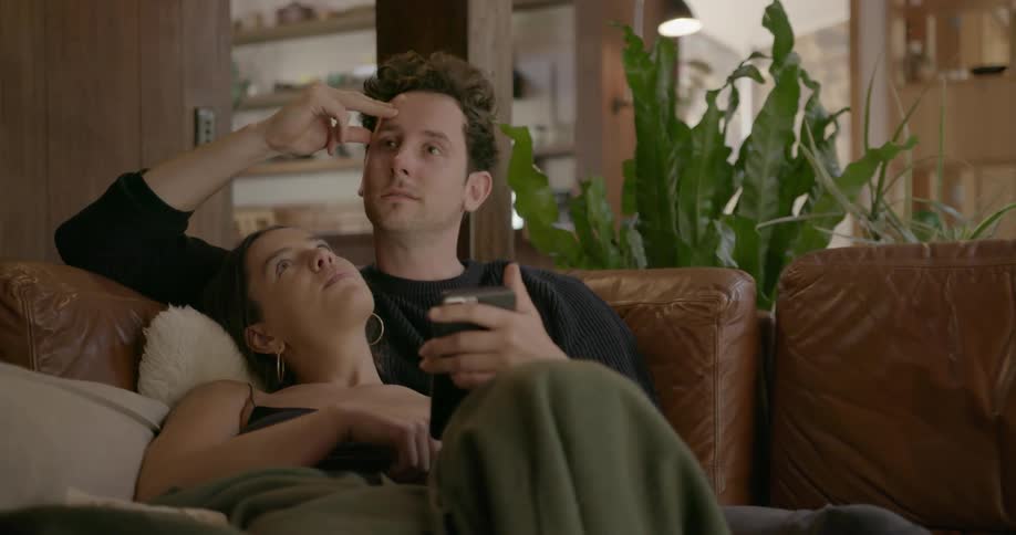 Man and woman sit close together on a sofa