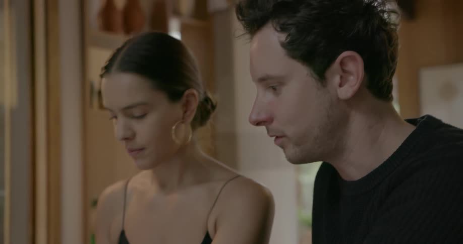 A man and woman work on a laptop