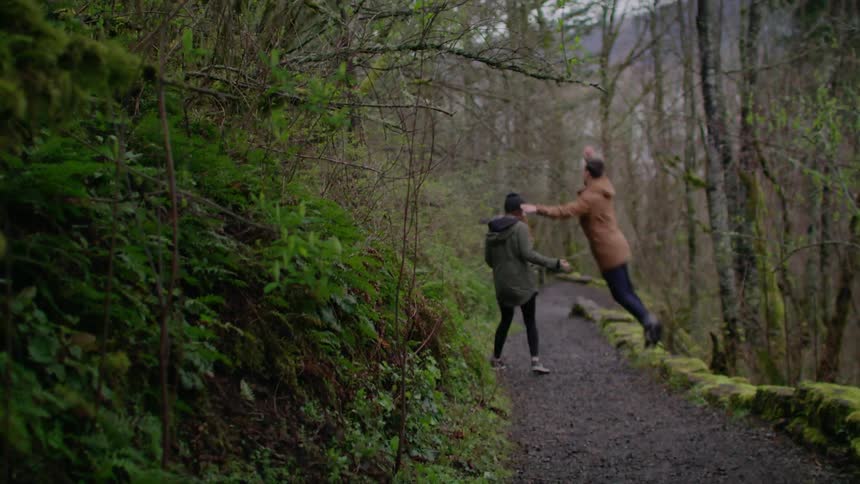 A couple walking on a path in the woods