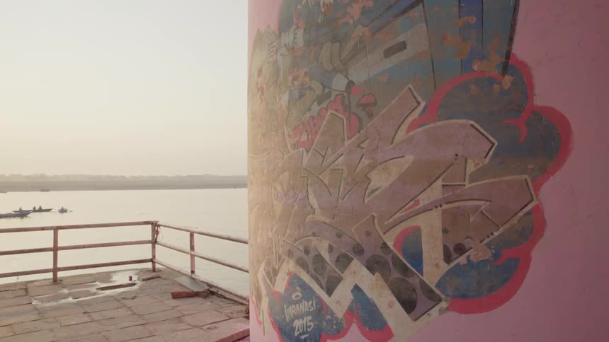 A mural is painted on a pillar next to a lake