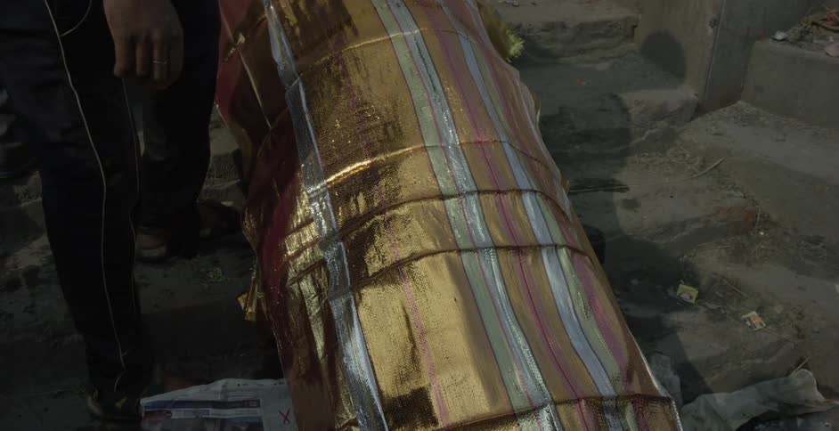 Person lays a shiny piece of cloth on top of another one