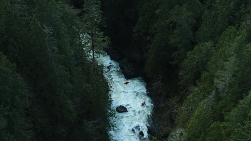 Two kayaks traverse a white water rapid