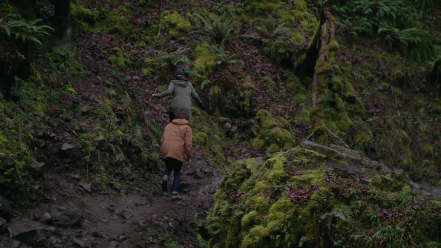 Man and woman climbing over rocky landscape