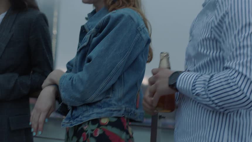 A man pops the top off a drink and hands it to a friend