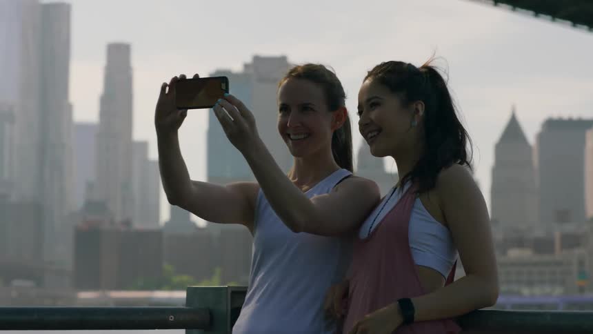 Two women joggers take a photograph together