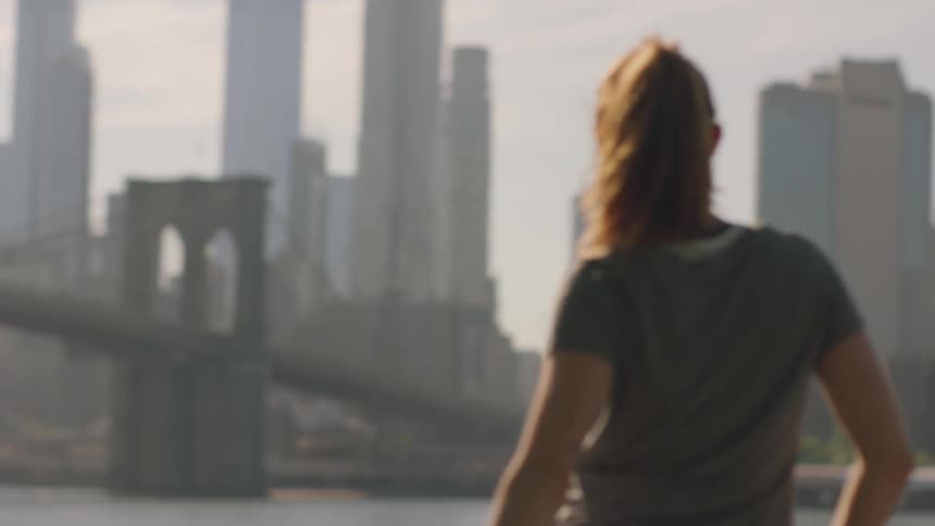 A woman does some stretches while looking at the city