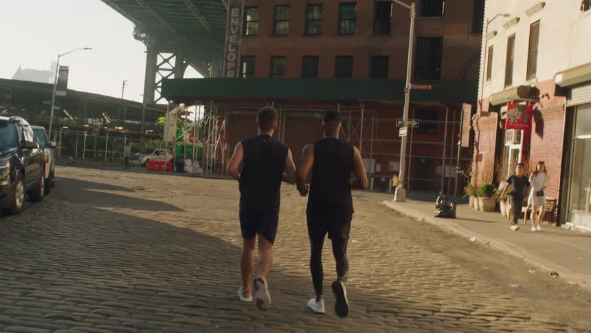 Two men jog on a city street