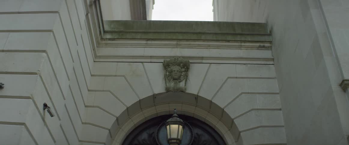A carving sits above a door on a city building