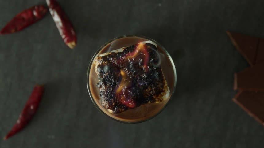 A person roasts a marshmallow with a blowtorch