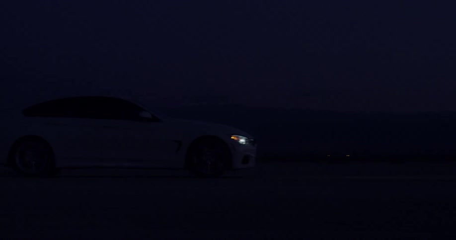 A vehicle travels down a road at night