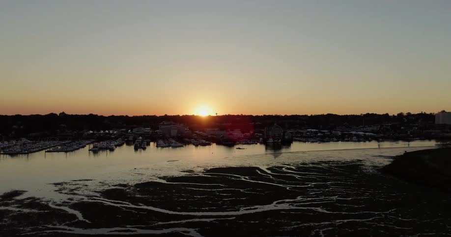 A boat dock is being filmed by a drone at sunset