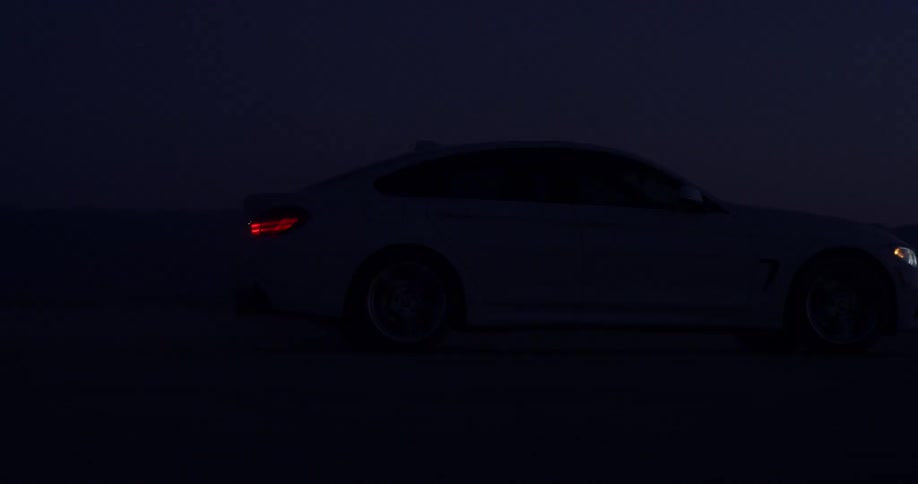 A car is driving through the desert at night