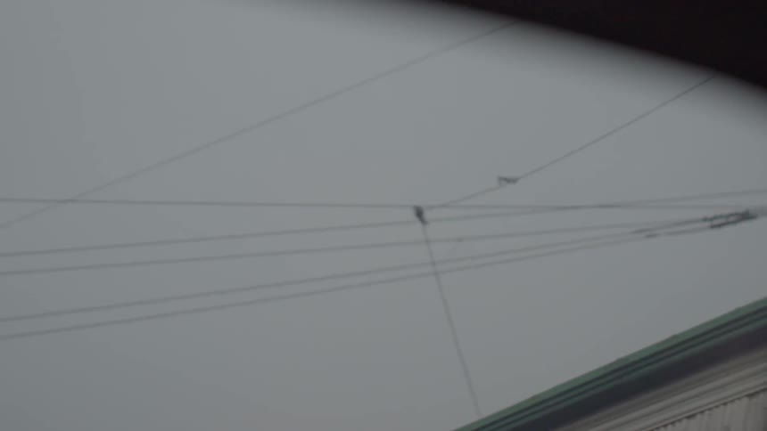There are many power lines lining the cloudy sky