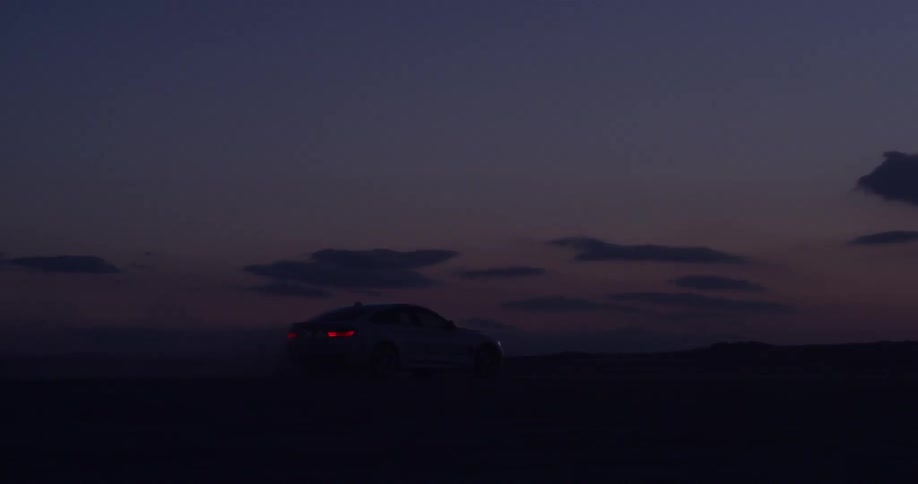 A vehicle drives through the desert