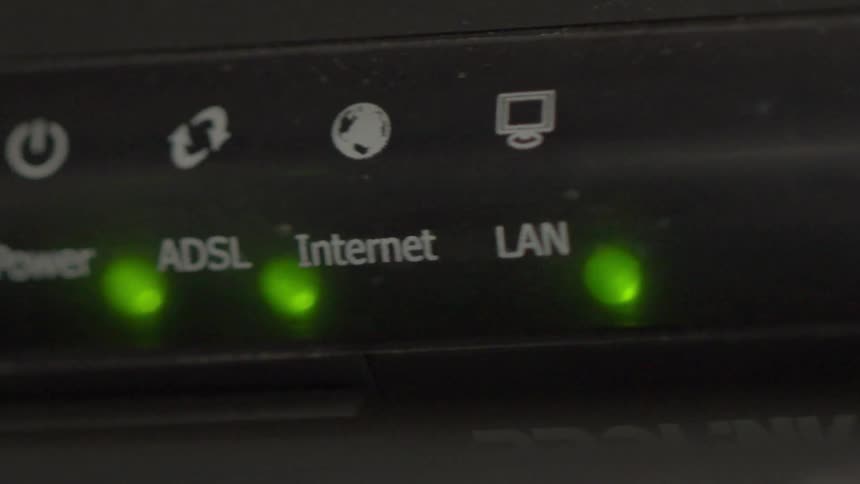 A modem is filmed close up with the lights blinking