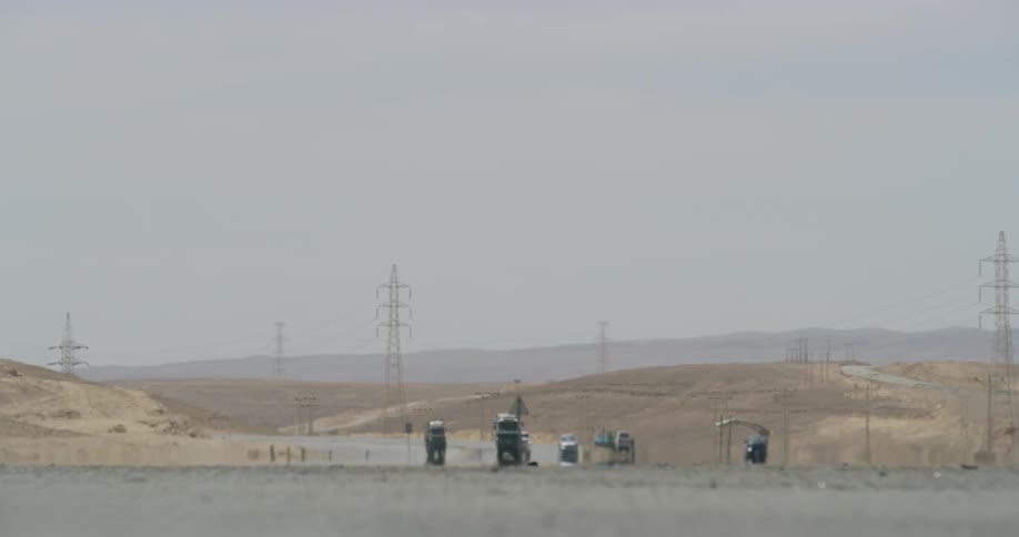 Cars drive on a sunny desert road