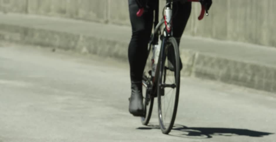 A person bikes down a concrete road