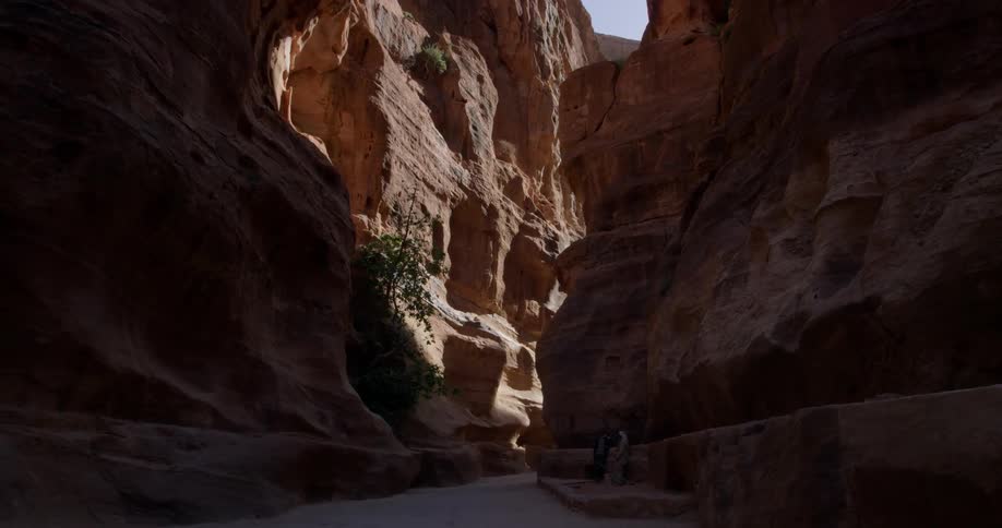 Two men stand near a wall of a gorge