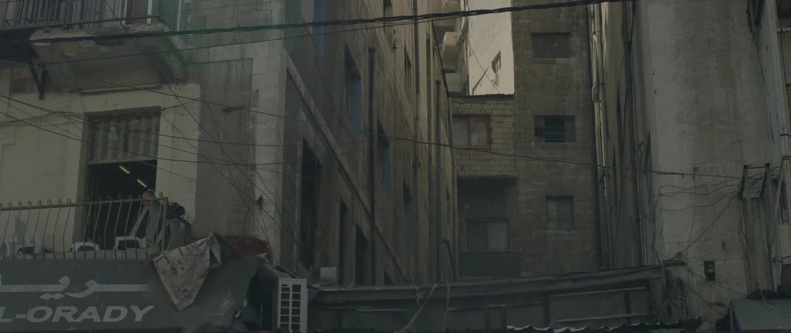 Electrical wires stretch between run down high-rise buildings