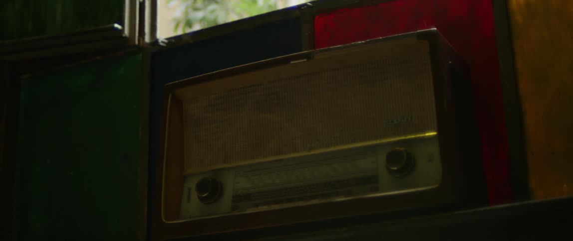 An old radio sits beneath a window