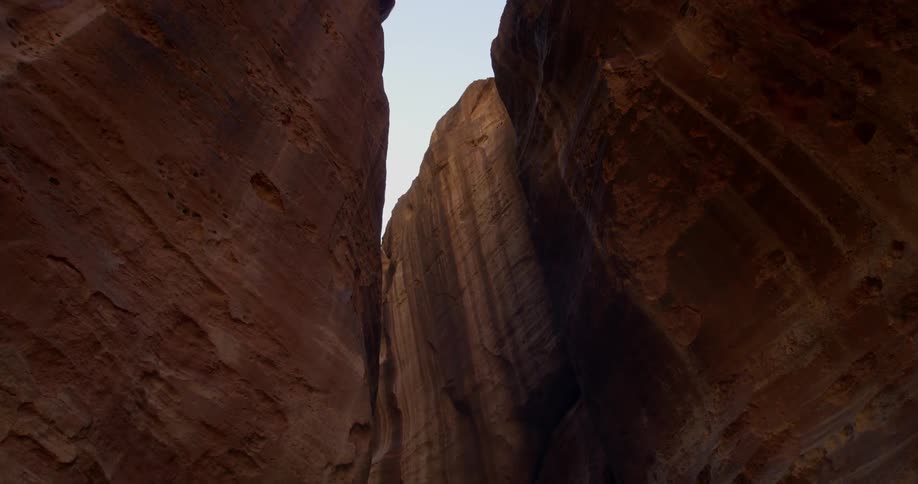 Someone is walking between two tall cliffs