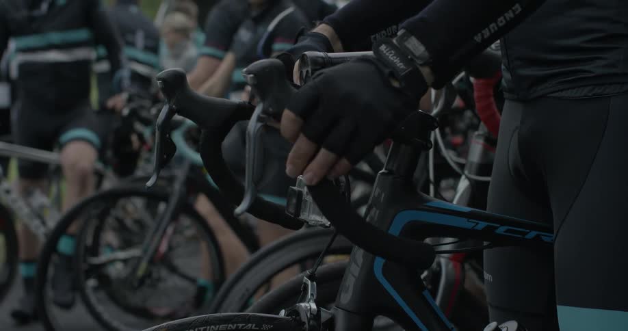 A group of bicyclists sit together on their bikes