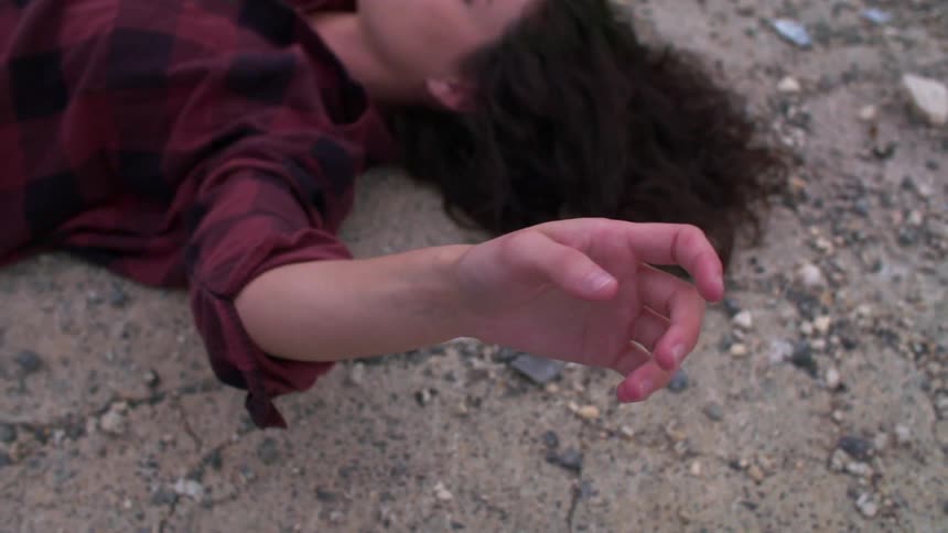 Woman laying on the stony ground