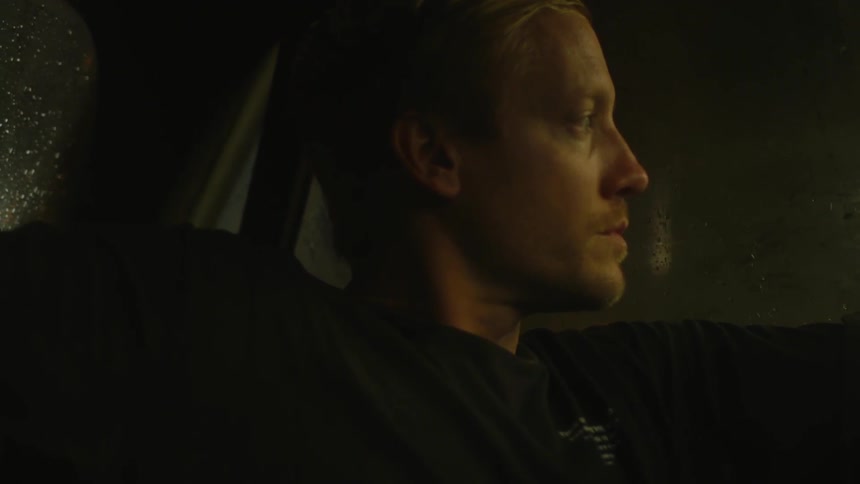 A man sits in the backseat of a car