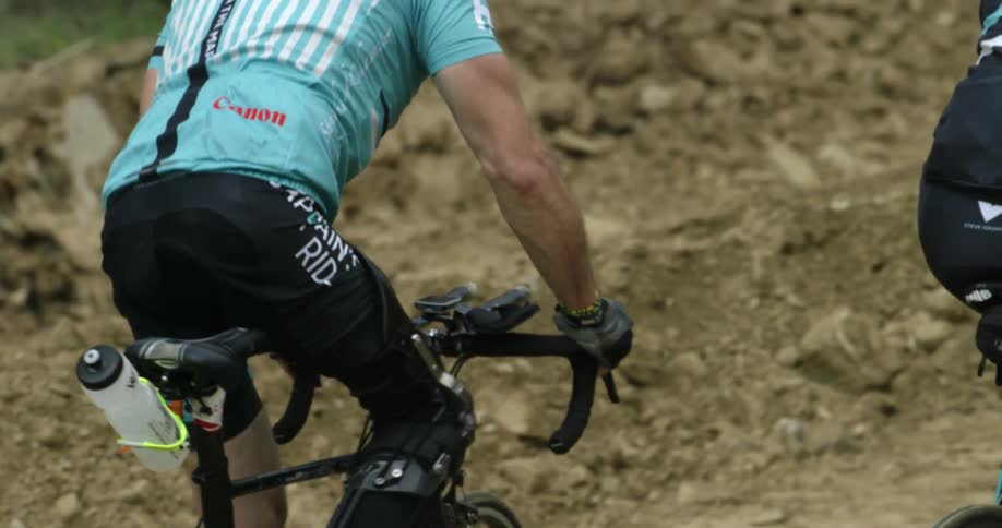 A person is riding a bike through some rocky dirt roads