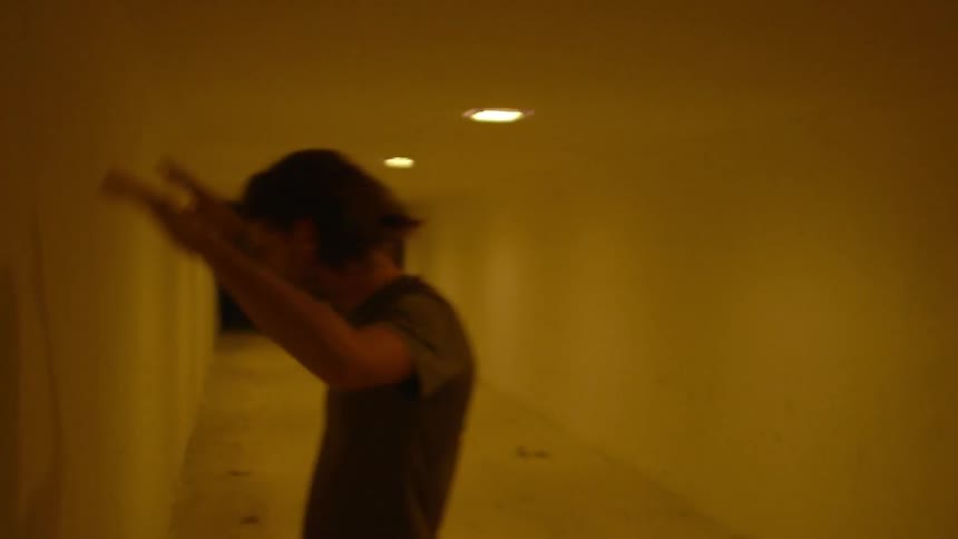 A man hits the wall in a brightly lit hallway