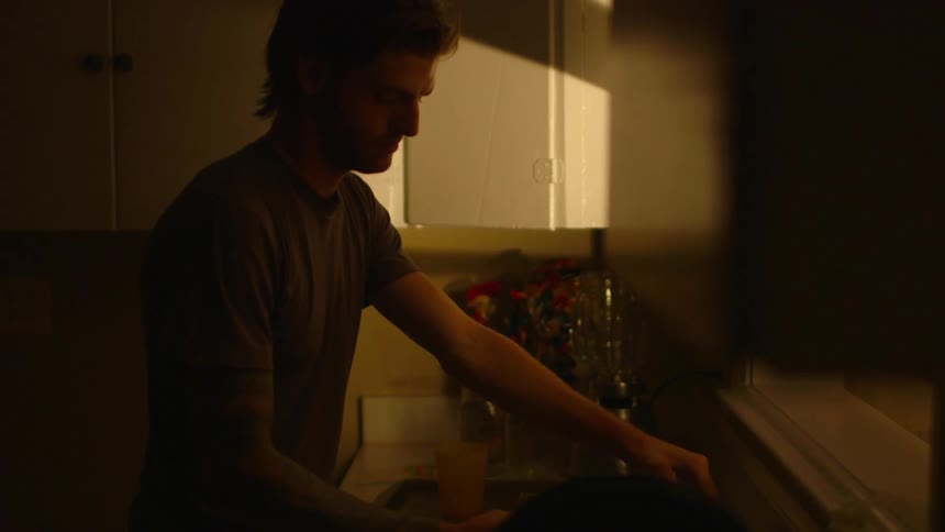 A man drinks water in the kitchen