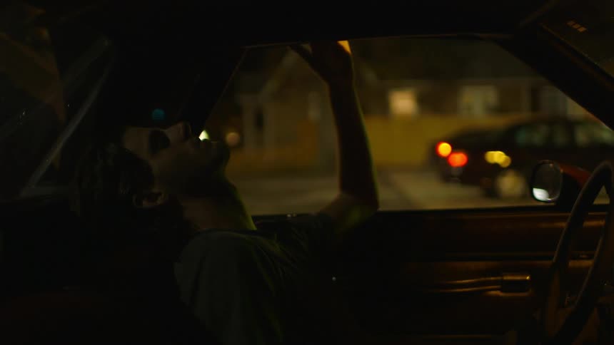 A man sits in the backseat of a car