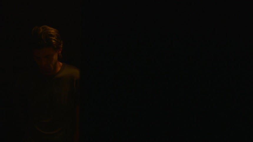A man stands in a dark room