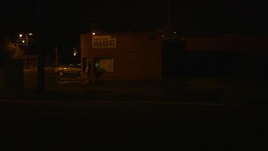 A man walks down a city street at night