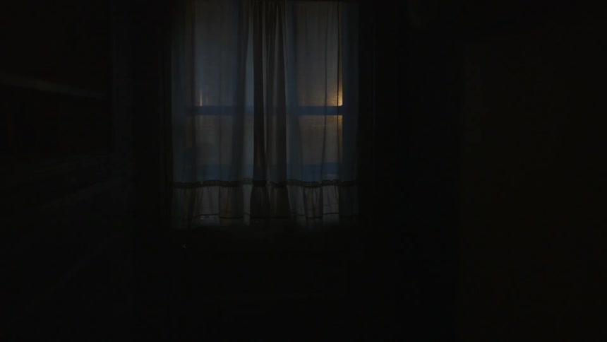 Curtains hang at a window blocking the sun