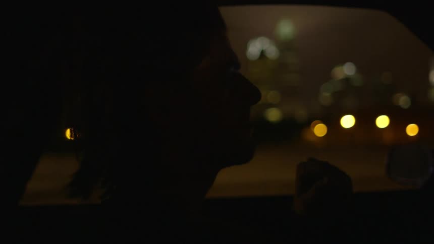 A person drives a car at night