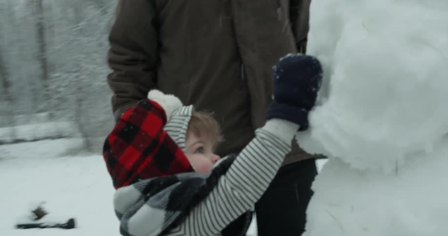 A family plays outside in the snow